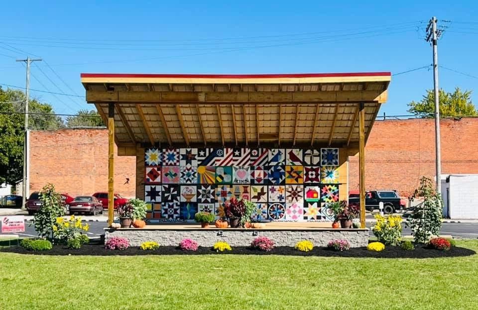 The wooden pavilion at night beside the UrbanWoody mural wall